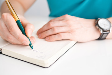 Man's hand writes a pen on diary