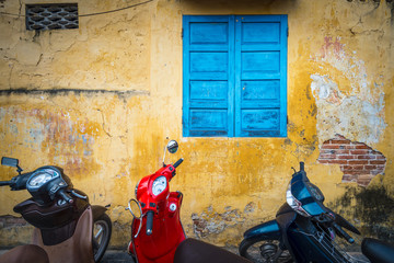Fototapeta premium Bikes parked near building with grungy wall.