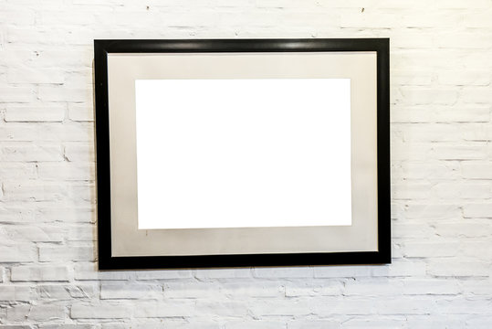 Black frame with blank space on brick wall.