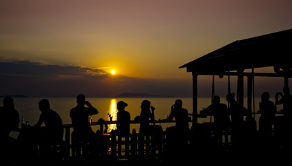 Fototapeta na wymiar Unrecognizable people enjoy beautiful sunset and drinks.
