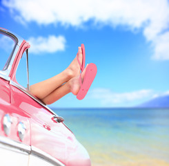 Woman legs by blue sea background in car