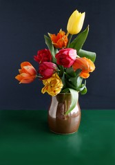 multicolor tulips in brown ceramic mug