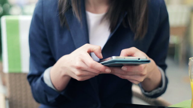 Businesswoman hands texting on modern smartphone in cafe