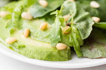 Green salad with avocado and pine nuts