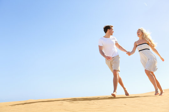 Happy couple holding hands running having fun