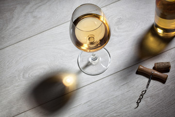 Glass of white wine on wooden table. Top view
