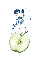 green apple dropped into water with bubbles isolated on white