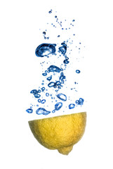 lemon and lime dropped into water with bubbles isolated on white