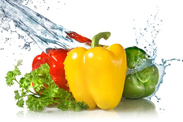 red, yellow, green pepper and parsley with water splash isolated