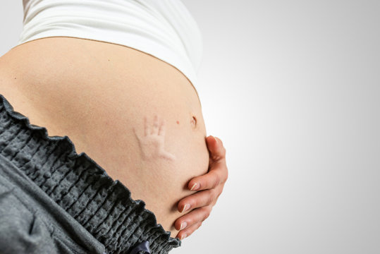Pregnant woman with a baby handprint on her tummy