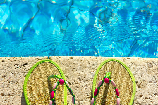 Two Flip Flops On The Platform Beside Swimming Pool