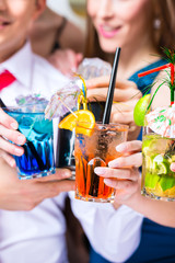 Cocktailgläser an Leuten in Bar beim Feiern