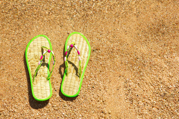 Pair of flip-flops in the wet sand at seaside