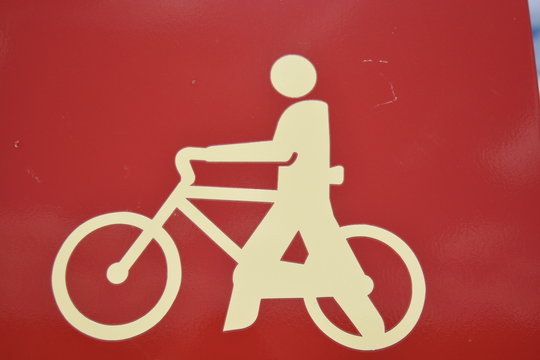 Simbolo de ciclista empujando una bicicleta a pie