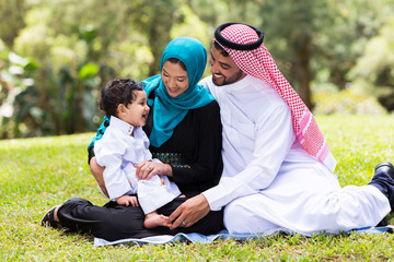 muslim family sitting outdoors
