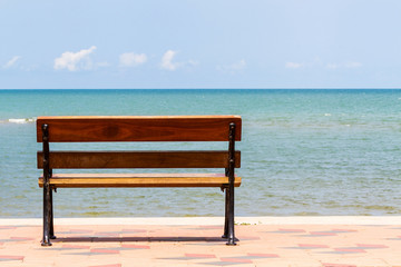 Fototapeta na wymiar Blue sea,long wood chairs at the tropical beach on blue sky.