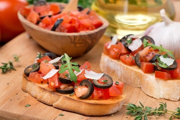 ciabatta with tomatoes, olives, parmesan on a wooden board