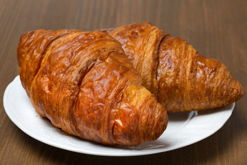 fresh croissants on a plate, close-up