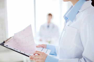 female holding clipboard with cardiogram