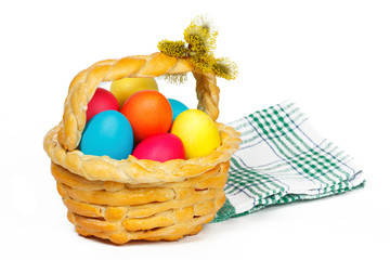 Baked basket with Easter colored eggs and bunch of pussy-willow