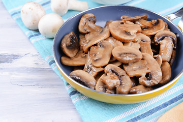Delicious fried mushrooms in pan on table close-up