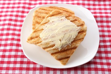 Grilled bread with butter on tablecloth