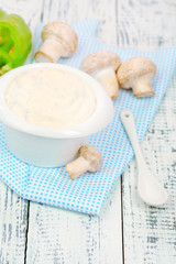 Delicate mushroom sauce in bowl on wooden table close-up