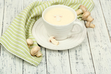 Delicate mushroom sauce in cup on wooden table close-up