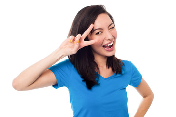 Excited girl doing victory sign on eye