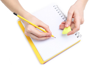Human hands with pencil and erase rubber and notebook, isolated