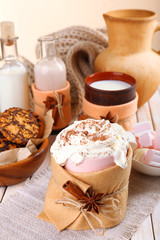 Fototapeta na wymiar Mug of hot drink decorated in felt on wooden table