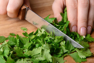 Chopped cilantro on wooden board close-up