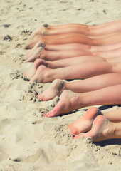 People sunbathing on the beach. Human feet.