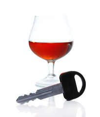 Composition with car key and glass of cognac, isolated on white