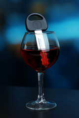 Composition with car key and glass of red wine,