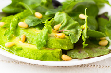 Green salad with avocado and pine nuts