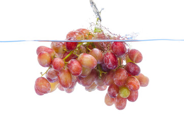 fresh grape dropped into water with splash isolated on white