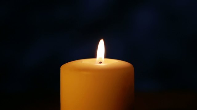 Candle on navy blue background