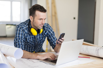 Contemporary construction worker with electronic equipment