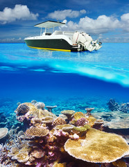 Beach and motor boat with coral reef underwater view