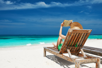 Young woman reading a book at beach