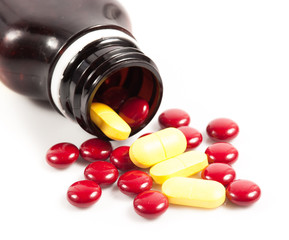 Little red and Yellow pills and tables with empty small jar