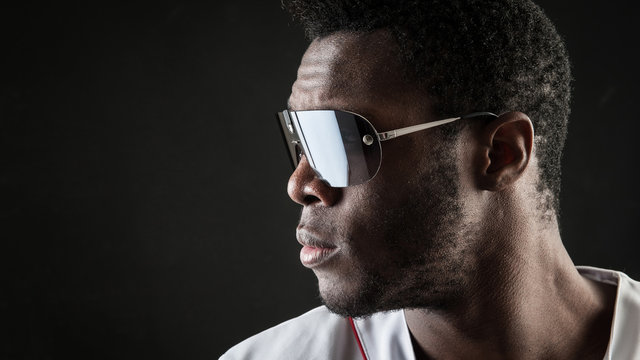 Confident black man close up portrait with sunglasses against da