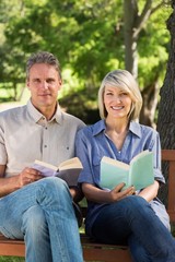 Couple holding books in park
