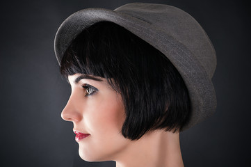 profile of a face of a beautiful woman in a male hat