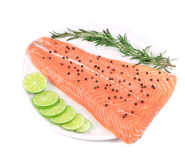 Uncooked salmon fillet with lime and herbs.