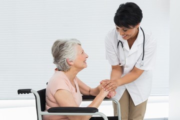 Obraz premium Female doctor talking to a senior patient in wheelchair