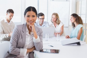 Casual businesswoman smiling at camera during meeting