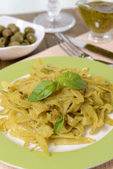 Delicious pasta with pesto on plate on table close-up