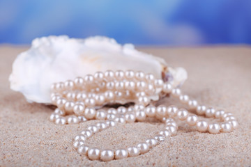 Beautiful pearls in shell on sand, close up